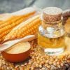 image showing two ears of corn on a table. This is accompanied by a small bottle of corn syrup.